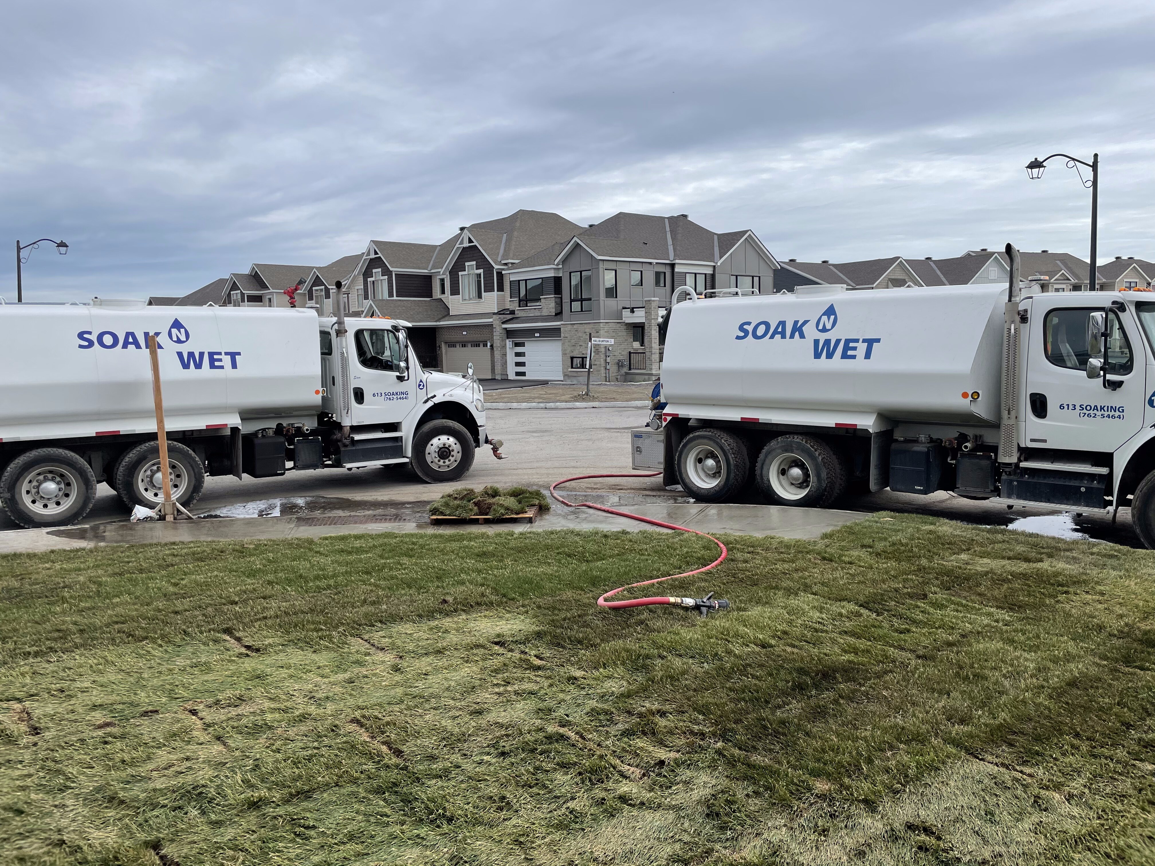 Two Soak N Wet trucks delivering water for landscaping